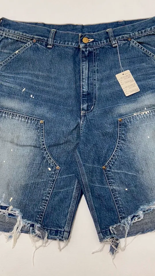 SAINT Mxxxxxx DOUBLE KNEE SHORTS/BLU Knee patches splashed with ink and water-splashed denim shorts. Denim blue S-XL. Custom-woven and dyed denim fabric with clear texture. Heavy-wash water-fading treatment to create local mottled fading/hole effects. Artificial distressing to simulate natural wearing marks. VINTAGE sense. Original consistent damage treatment. Hand-splashed ink and paint. Original consistent wash mark/pocket mark. Double knee patch. Rivet reinforcement. Improve functionality while enhancing design